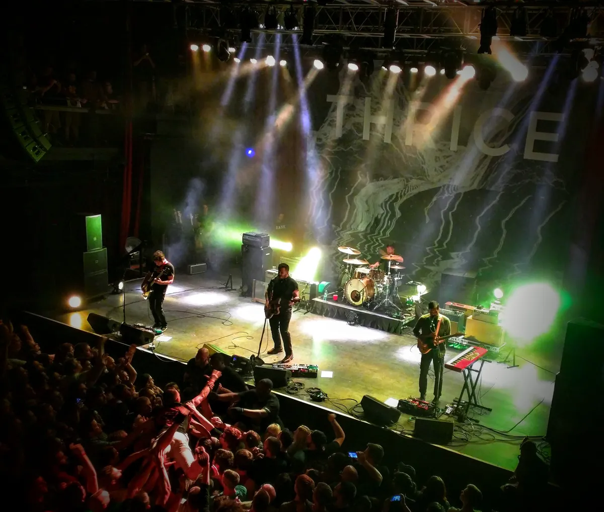 Thrice on stage at Rams Head Live in Baltimore lit from behind by green and yellow lights